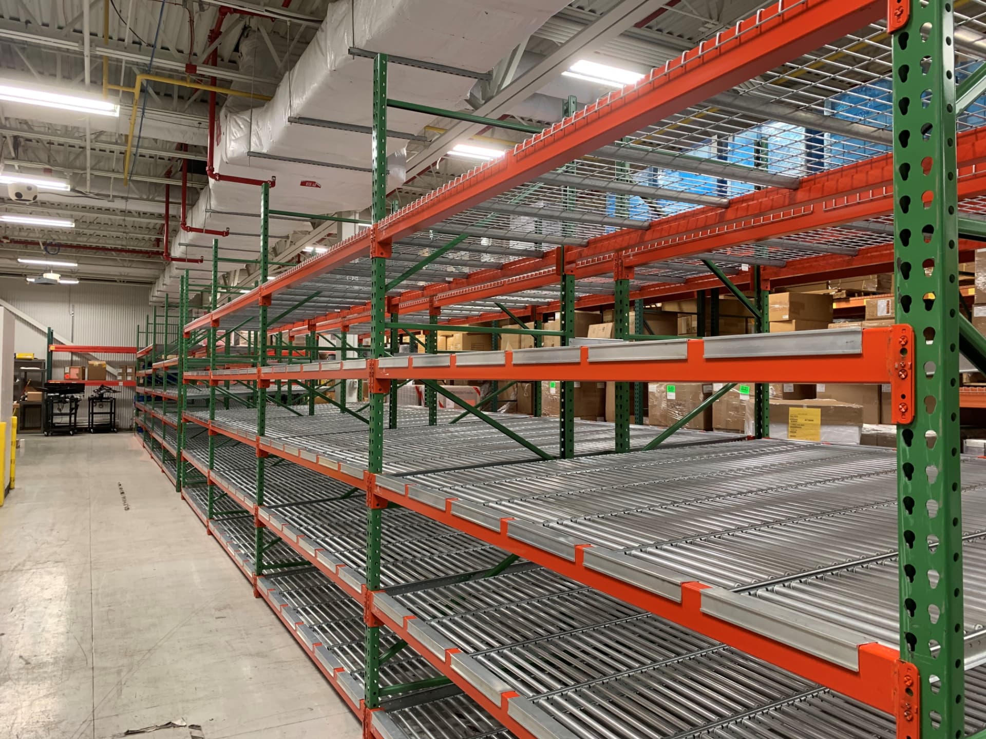 Carton flow rack bays with gravity roller beds